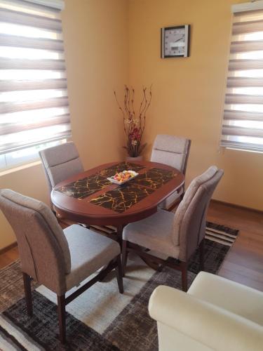 - une salle à manger avec une table et des chaises en bois dans l'établissement Apartman ,,LOVAC" Nova Varoš, à Branoševac