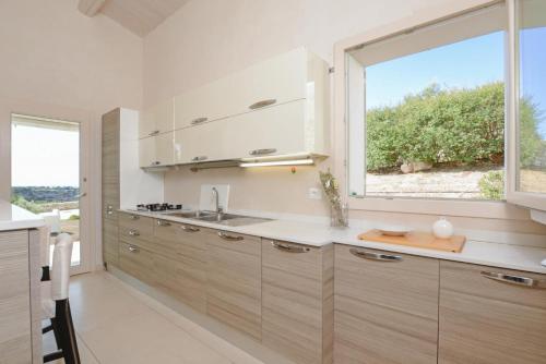 eine Küche mit einem Waschbecken und einem großen Fenster in der Unterkunft Villa Paola in Scicli
