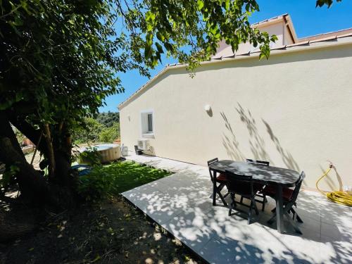 a table and a chair sitting next to a building at Maison d’hôtes Joséphine in Ajaccio