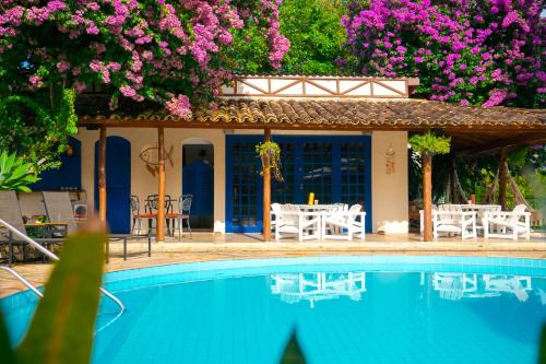 una casa con piscina y flores en Pousada Una, en Barra do Una