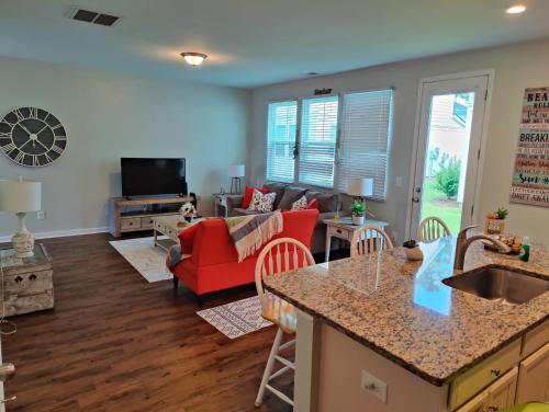 eine Küche und ein Wohnzimmer mit einem roten Sofa in der Unterkunft Golf Resort, Beach, Entire House in Myrtle Beach