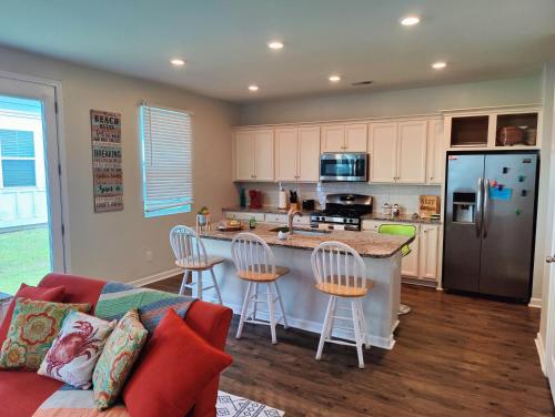 a kitchen with a couch and a kitchen island with bar stools at Golf Resort, Beach, Entire House in Myrtle Beach