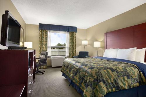une chambre d'hôtel avec un lit et une télévision dans l'établissement Travelodge by Wyndham Oshawa Whitby, à Oshawa
