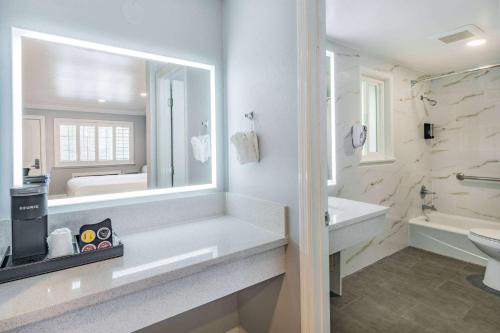 a bathroom with a sink and a toilet and a mirror at Super 8 by Wyndham Monterey Fisherman's Wharf Aquarium in Monterey