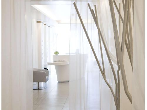 a white room with a chair and a table at Novotel Marseille Vieux Port in Marseille