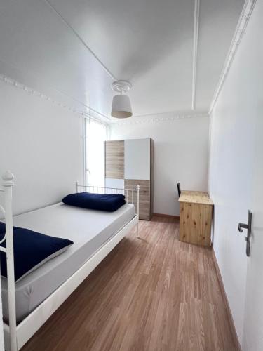 巴纽Bel appartement proche Paris métro 4的卧室配有一张白色床和木地板