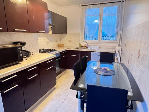 巴纽Bel appartement proche Paris métro 4的带桌子和微波炉的小厨房
