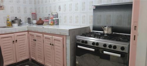 a kitchen with a stove and white cabinets at amine adnane in Safi