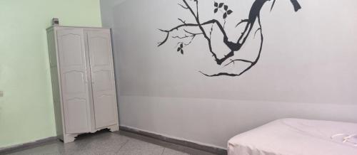 1 dormitorio con una pared blanca con una rama en la pared en amine adnane en Safi