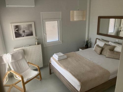 a bedroom with a bed and a chair and a mirror at Enchanting Mycenae - Your Greek holiday retreat in Argos