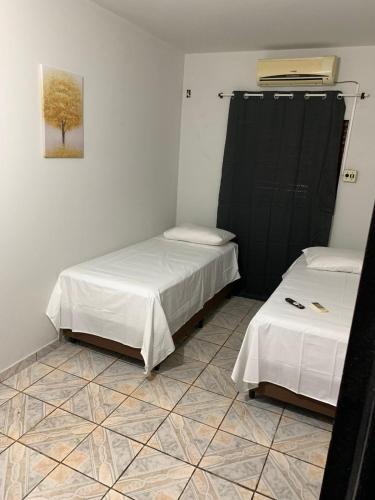 a room with two beds and a tiled floor at Cerrado Plaza Hotel -dourados in Dourados