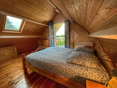a bed in a room with a wooden ceiling at Gite du lac du Palentin Ardres in Ardres