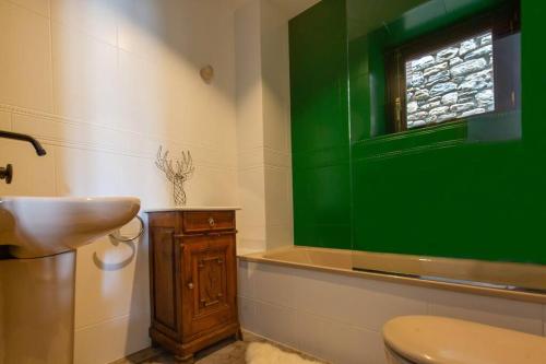 uma casa de banho com um WC e uma janela verde em Casa Jarca 1er piso, a 1km de Canillo em Canillo