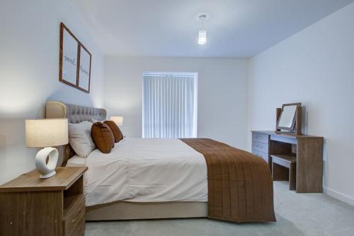 a bedroom with a bed and a desk and a television at Brand New apartment next to Lakeside Shopping mall, Essex in West Thurrock