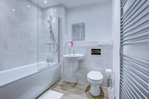 a white bathroom with a toilet and a sink at Brand New apartment next to Lakeside Shopping mall, Essex in West Thurrock