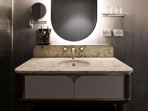 a bathroom with a sink and a mirror at The Playford Adelaide - MGallery in Adelaide