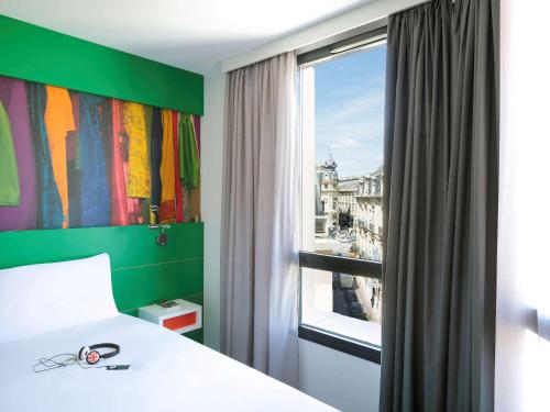 1 dormitorio con cama y ventana con vistas en ibis Styles Montpellier Centre Comedie, en Montpellier