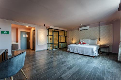 1 dormitorio con cama blanca y suelo de madera en Hotel MID Project en Mérida