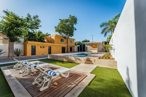 a backyard with two lounge chairs and a swimming pool at Hotel MID Project in Mérida