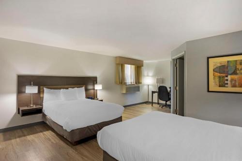 a hotel room with two beds and a desk at Best Western DuBois Hotel in DuBois