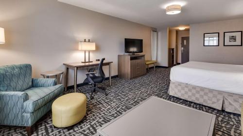 a hotel room with a bed and a couch and a desk at Best Western DuBois Hotel in DuBois