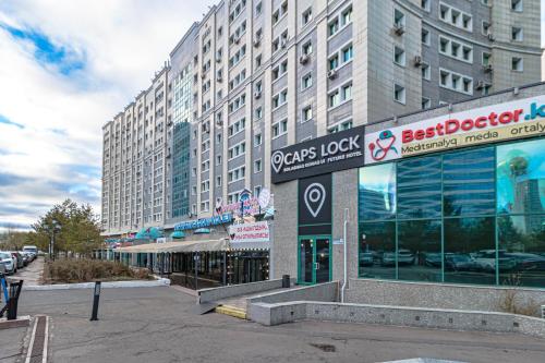 a building with a sign in front of it at CAPS LOCK Future Hotel in Astana