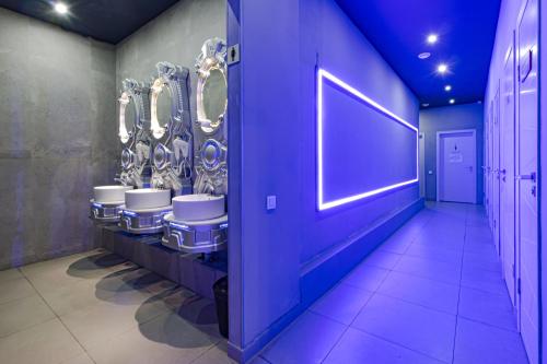 a row of sinks in a bathroom with a row of mirrors at CAPS LOCK Future Hotel in Astana