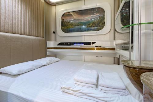 a bed in a room with a window and towels at CAPS LOCK Future Hotel in Astana