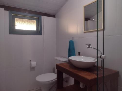 a bathroom with a sink and a toilet and a window at Casas Porto Belo, um recanto a 100 metros da praia in Porto Belo