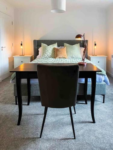 a room with a table and a couch with a bed at Modern flat near train station with free parking in Cambridge