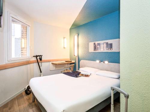 1 dormitorio con 1 cama blanca en una habitación en Ibis Budget Lille Gares Vieux-Lille, en Lille
