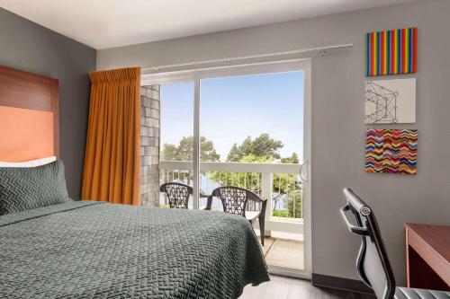 a bedroom with a bed and a sliding glass door at Travelodge by Wyndham Depoe Bay in Depoe Bay