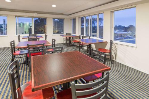 a restaurant with tables and chairs and windows at Travelodge by Wyndham Depoe Bay in Depoe Bay