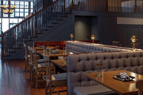 a restaurant with tables and chairs and stairs at Hilton Garden Inn Downtown Dallas in Dallas