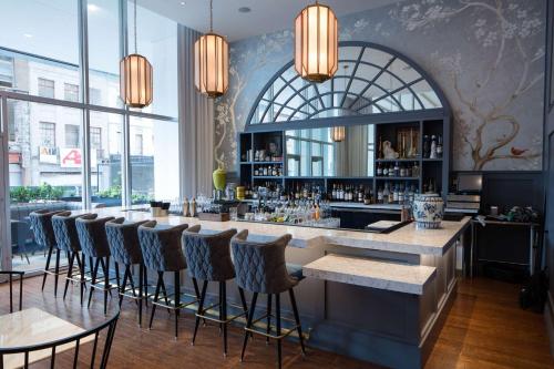 a bar with chairs and a counter in a room with windows at Hilton Garden Inn Downtown Dallas in Dallas