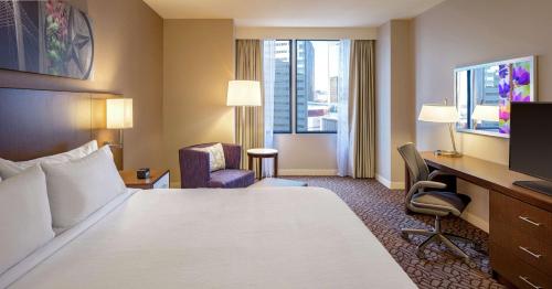a hotel room with a bed and a desk and a television at Hilton Garden Inn Downtown Dallas in Dallas