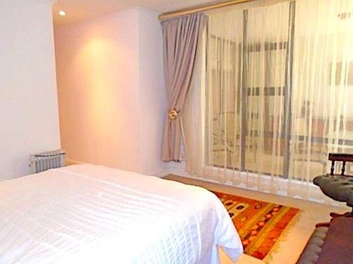 ein Schlafzimmer mit einem weißen Bett und einem Fenster in der Unterkunft Executive apartment - Sandton in Johannesburg