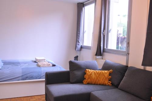 - un salon avec un canapé et un lit dans l'établissement Cosy studio paris13 10min to Louvre, à Paris