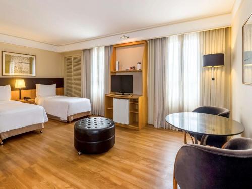 um quarto de hotel com duas camas e uma mesa em Pergamon SP Frei Caneca by Accor em São Paulo