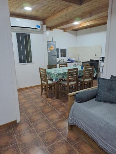 a living room with a table and chairs and a kitchen at NEUQUEN alojamiento in Neuquén