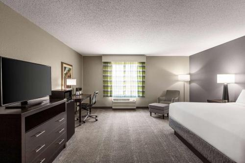 a hotel room with a bed and a flat screen tv at Wingate by Wyndham Savannah I-95 North in Port Wentworth