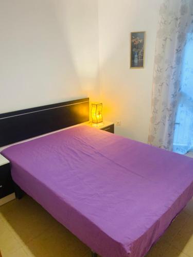 a large purple bed in a white room at Habitación privada in Calafell