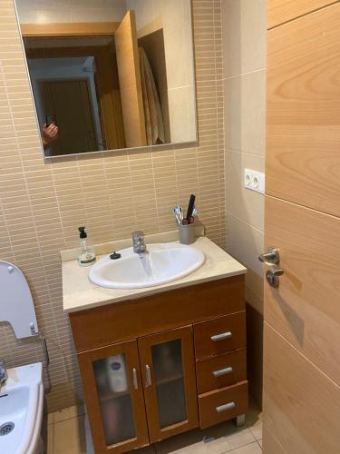 een badkamer met een wastafel en een spiegel bij Habitación privada in Calafell