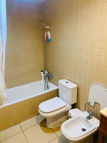 een badkamer met een toilet, een bad en een wastafel bij Habitación privada in Calafell