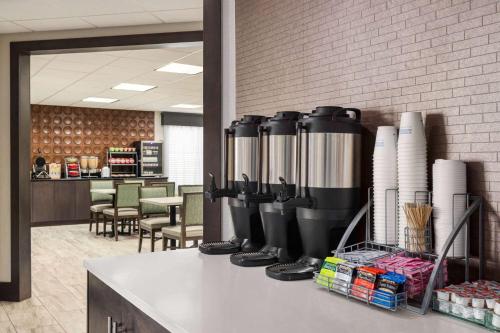 a restaurant with a row of water tanks on a counter at Wingate by Wyndham Savannah I-95 North in Port Wentworth