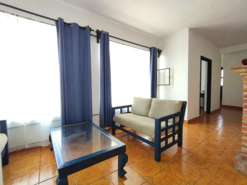 a living room with a chair and a glass table at Hotel & Hostal Santuario in San Miguel de Allende