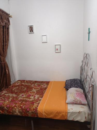 a small bed in a room with a cross on the wall at DON- PABLITo in Quito