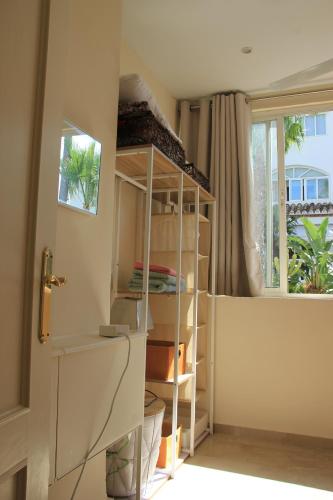 um quarto com uma estante de livros e uma janela em Chalet adosado en urbanización con piscina em Estepona