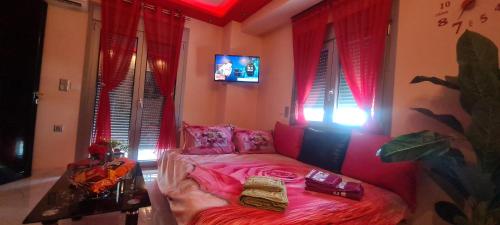 a room with a pink bed in a room with windows at Perfect Suites in Neos Marmaras