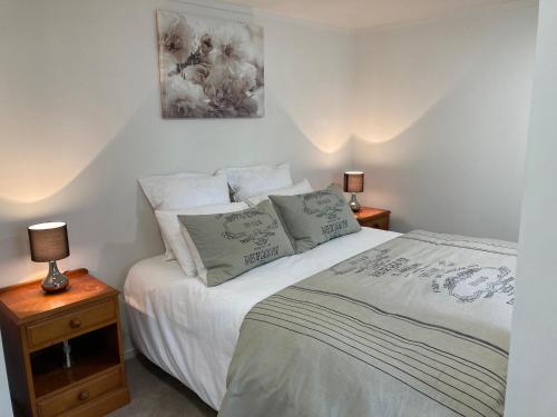 a bedroom with a white bed with two lamps at Rotorua Tranquility in Rotorua